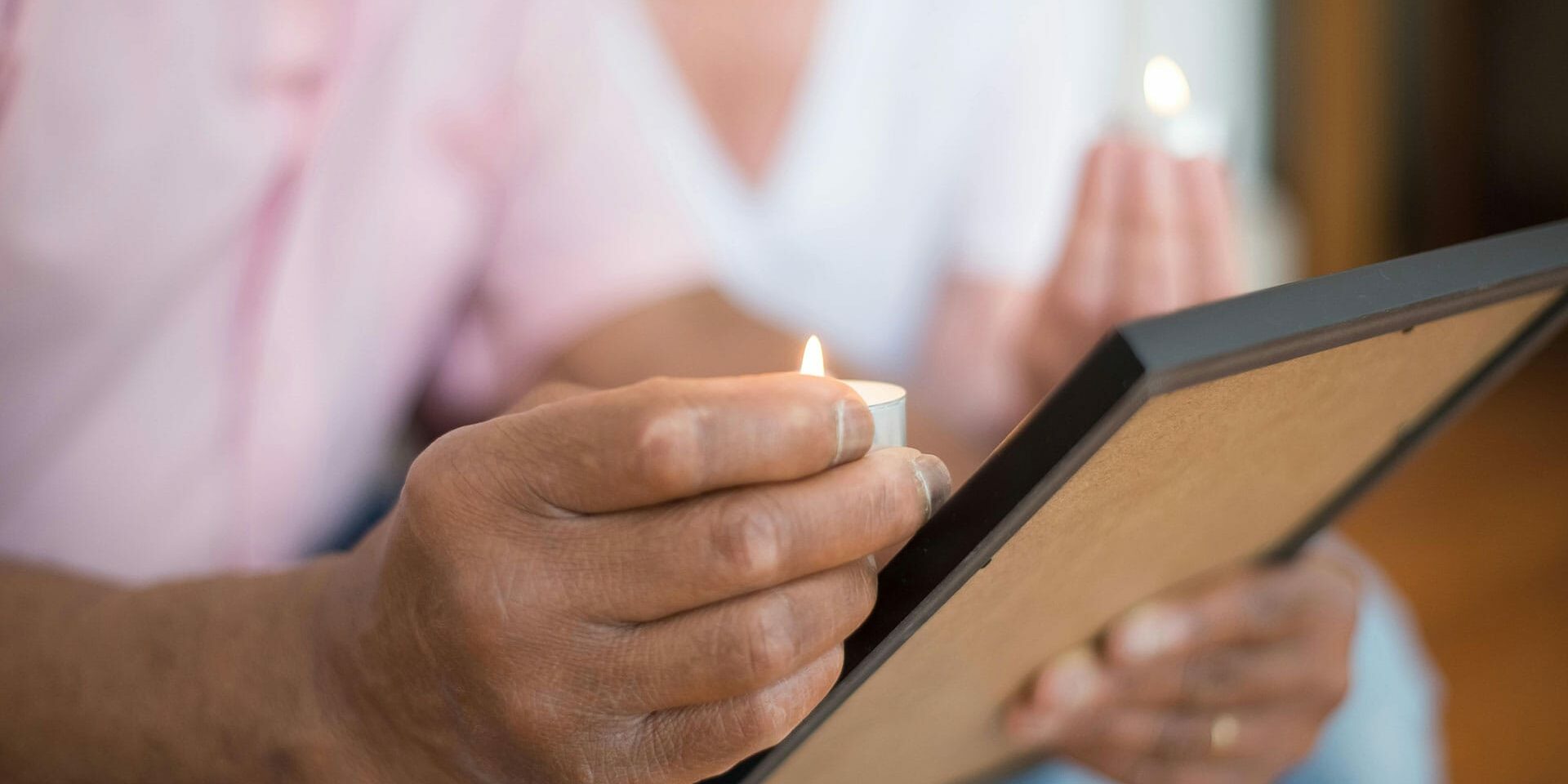 hands-holding-photo-frame-and-candle-together